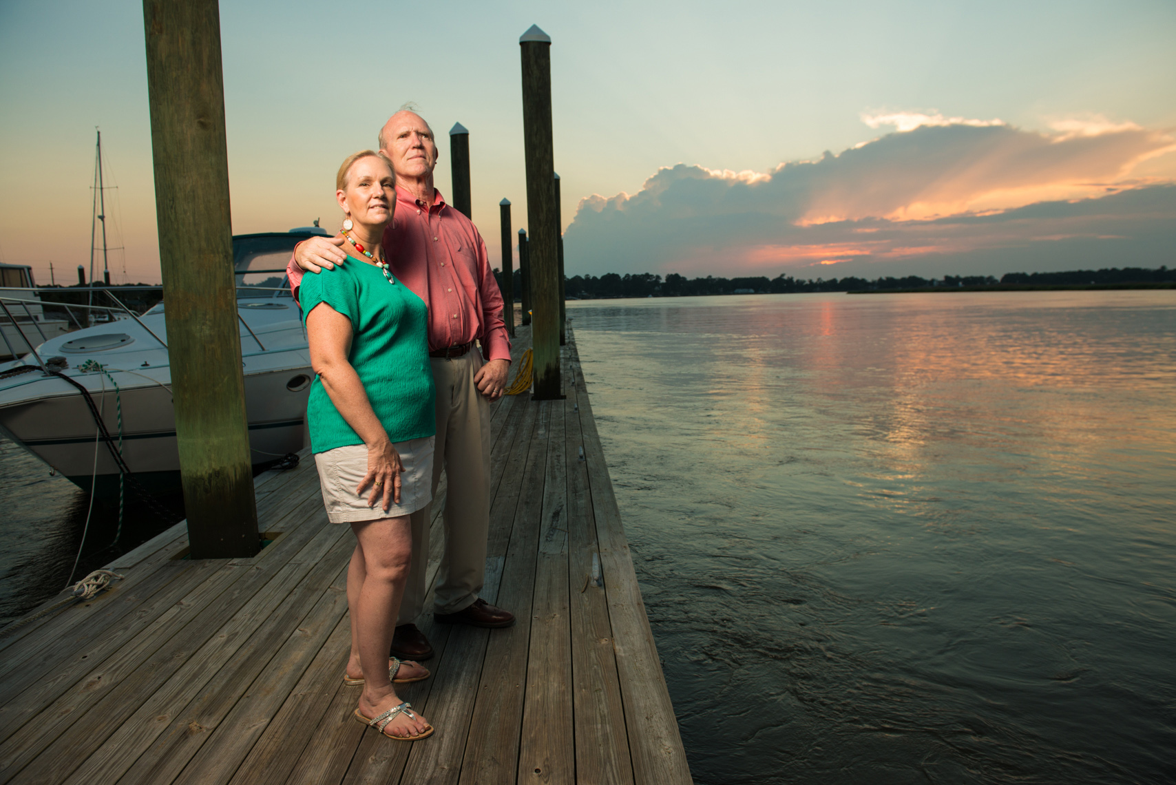 older couple watches sunset on the dock 