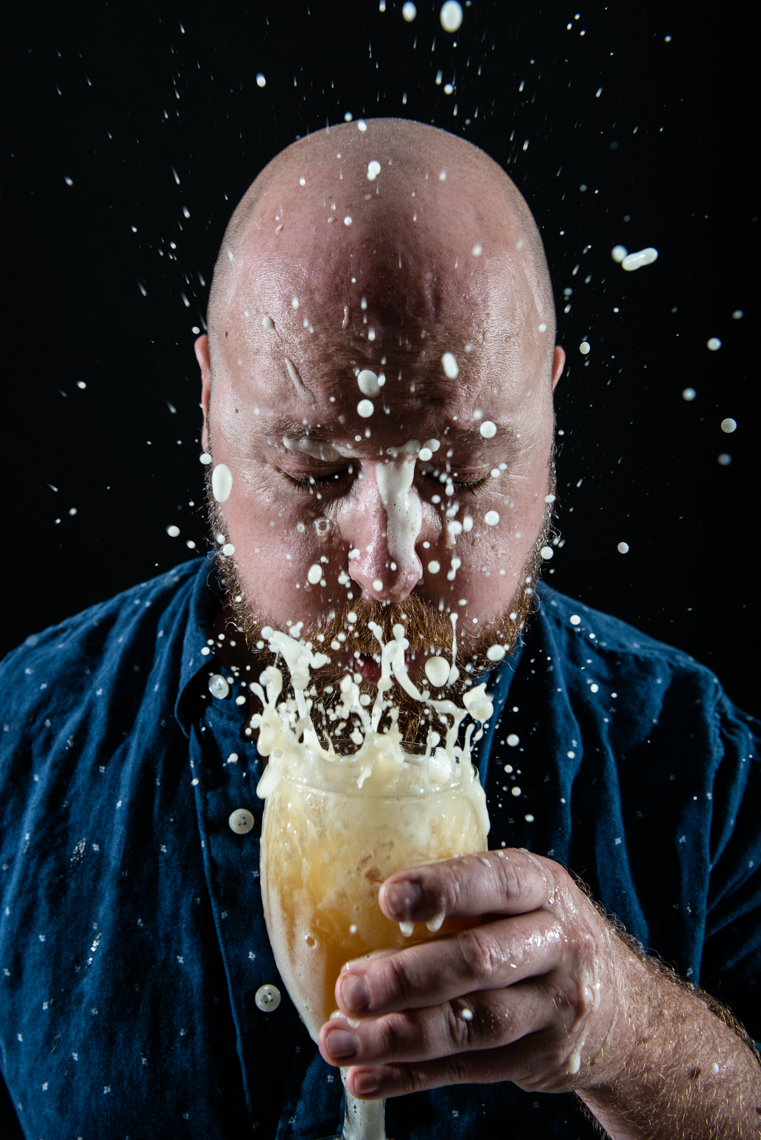 bald man blows beer foam