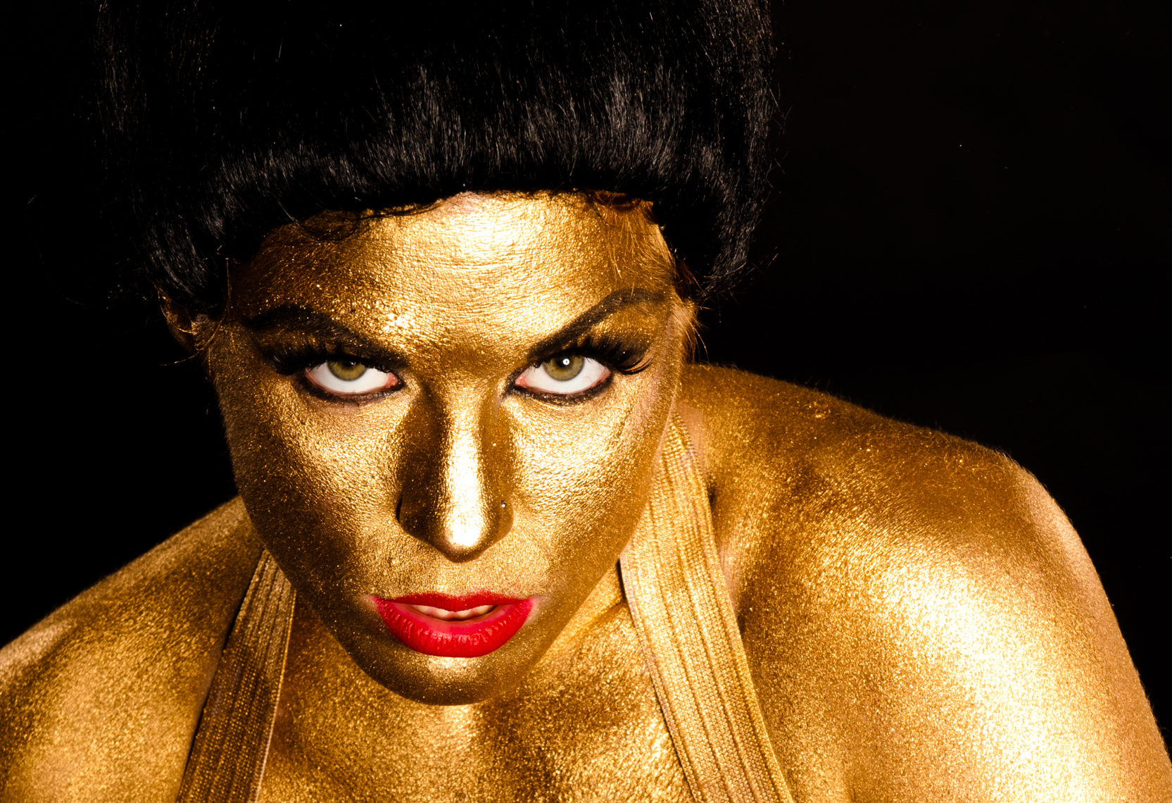 female model covered in head to toe gold makeup